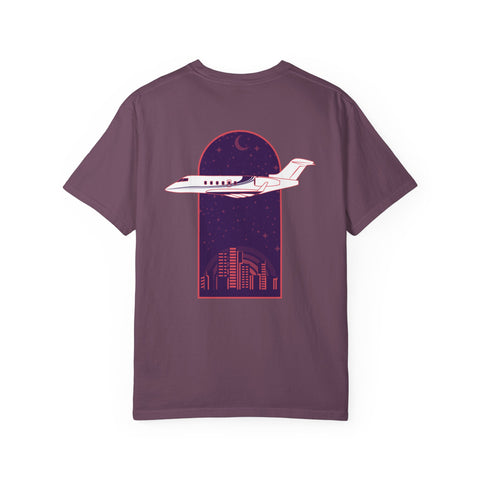 Purple t-shirt with airplane and cityscape design on a white background